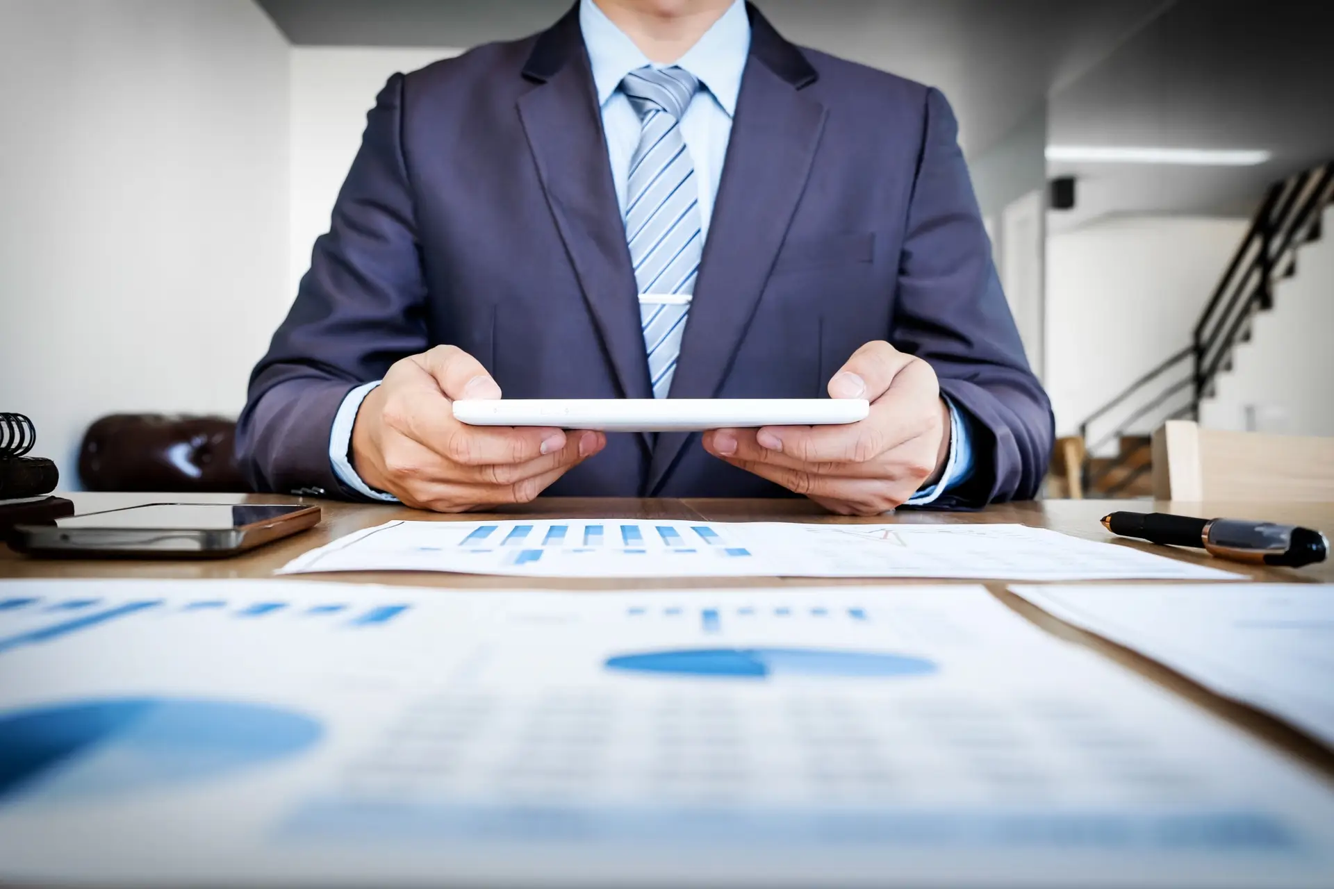 multitasking-handsome-young-man-working-with-touchpad-while-sitting-couch-office-financial-statistic-graph_1423-117